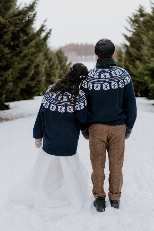 Couple in winter knitwear and mittens, photographed in the Hokkaido snow